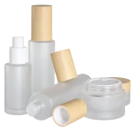 Frosted glass bottles and cream jars with woodgrain caps