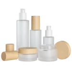 Frosted glass bottles and cream jars with woodgrain caps