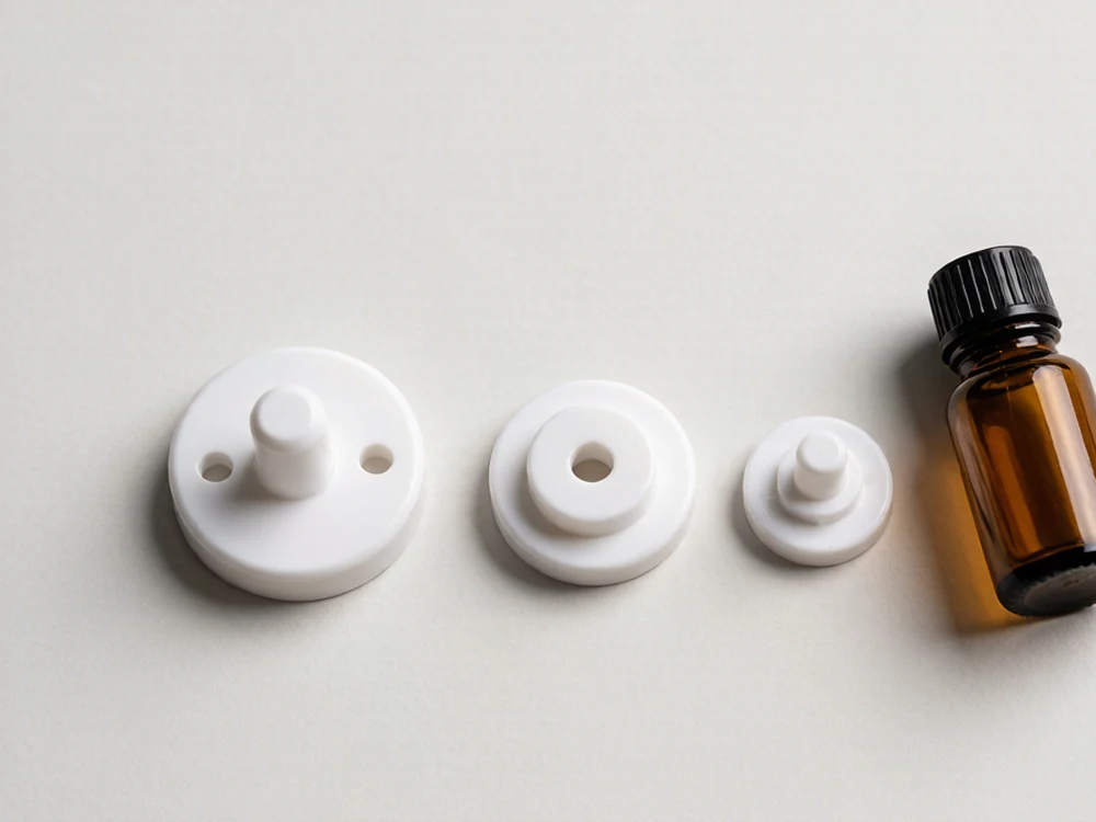 Three white orifice reducer inserts with different hole sizes in a flat lay