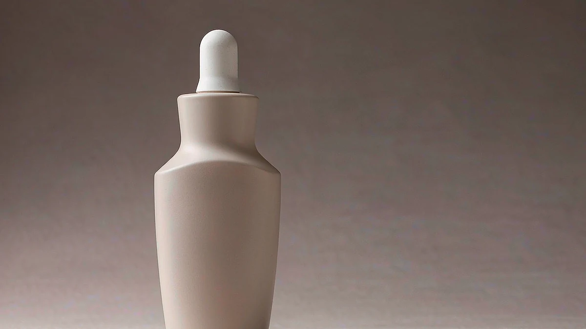 Macro of a single frosted matte cosmetic dropper bottle with a soft-touch surface
