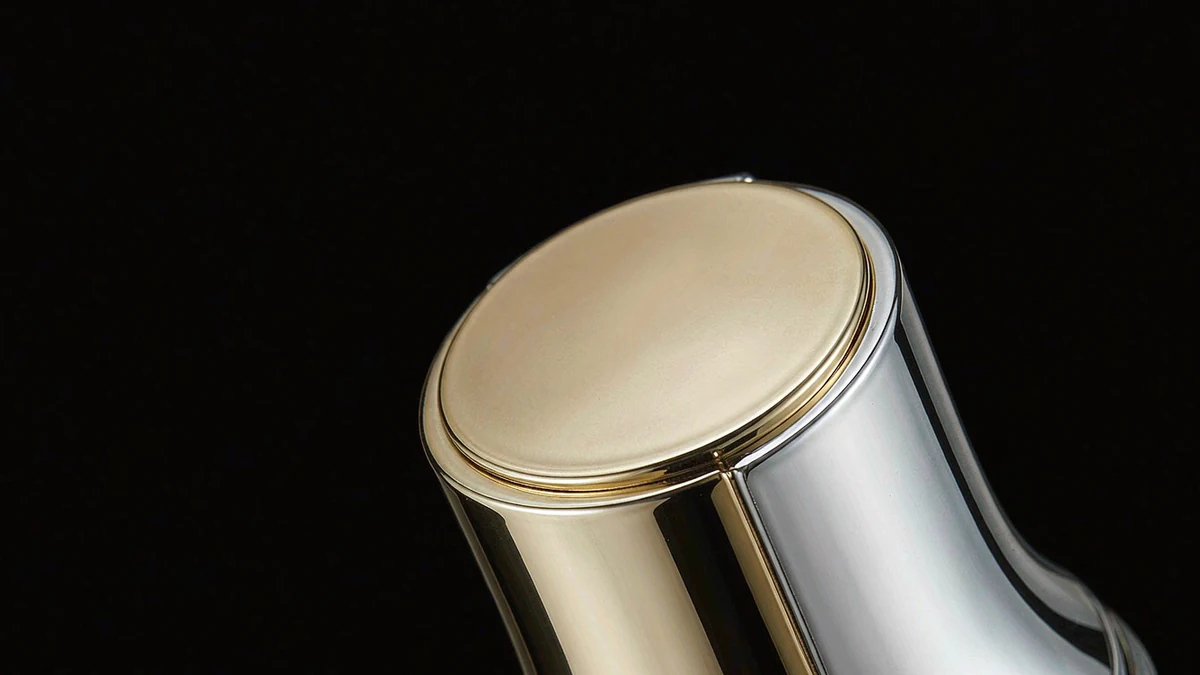 Gold and chrome vacuum-metallized cosmetic cap and shoulder showing a mirror finish