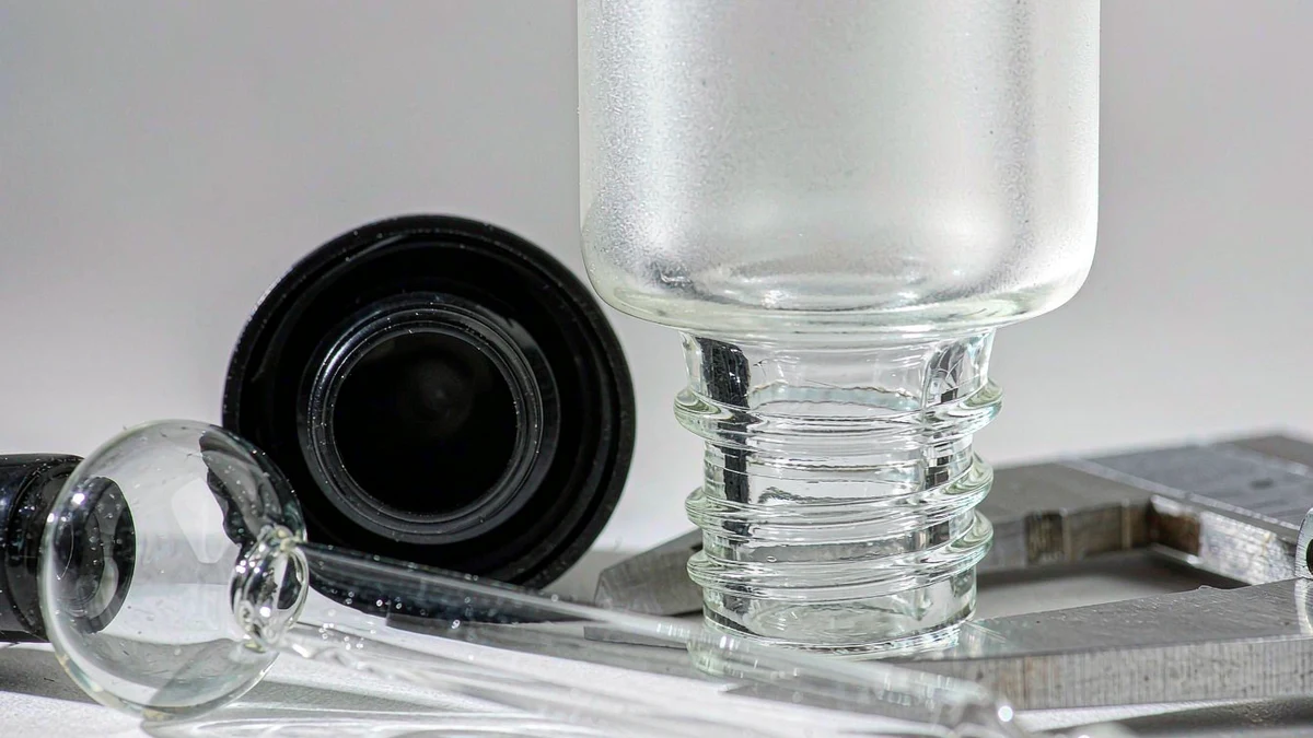 Cosmetic bottle technical drawing and specification sheet on a desk with calipers, showing neck finish and capacity dimensions