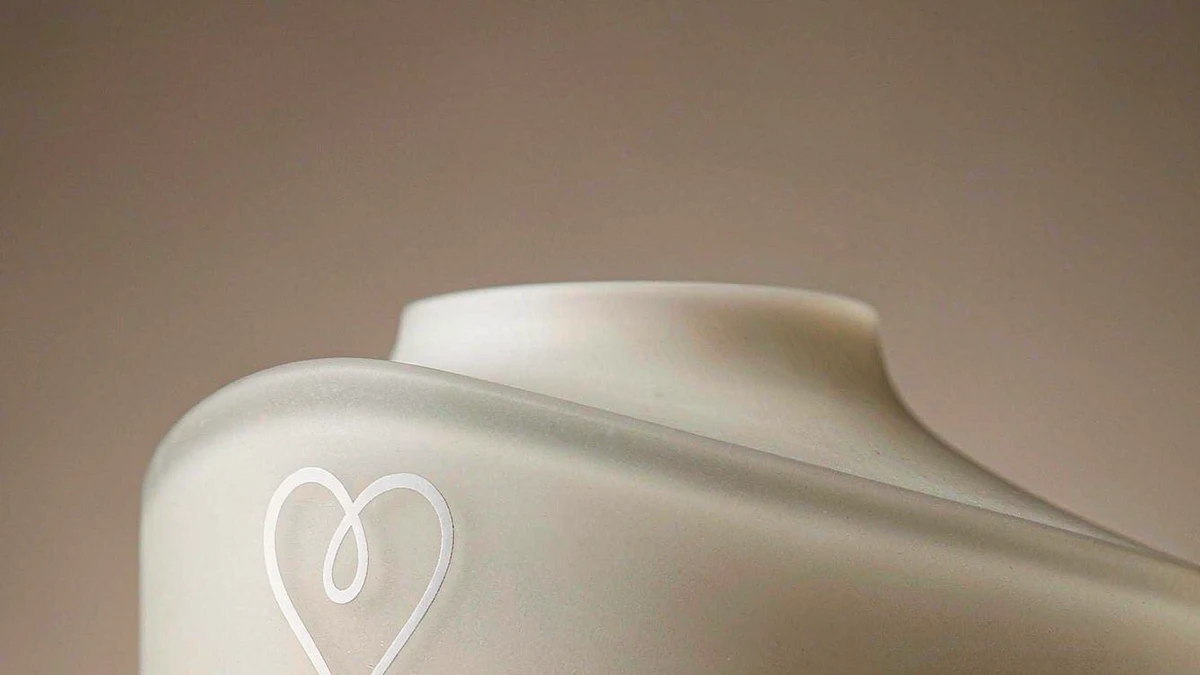 Close-up of a cosmetic bottle neck with screen-printed logo and gold hot-stamp accent