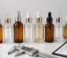 Cosmetic packaging quality inspection station with glass bottles, a digital caliper and a QC checklist clipboard